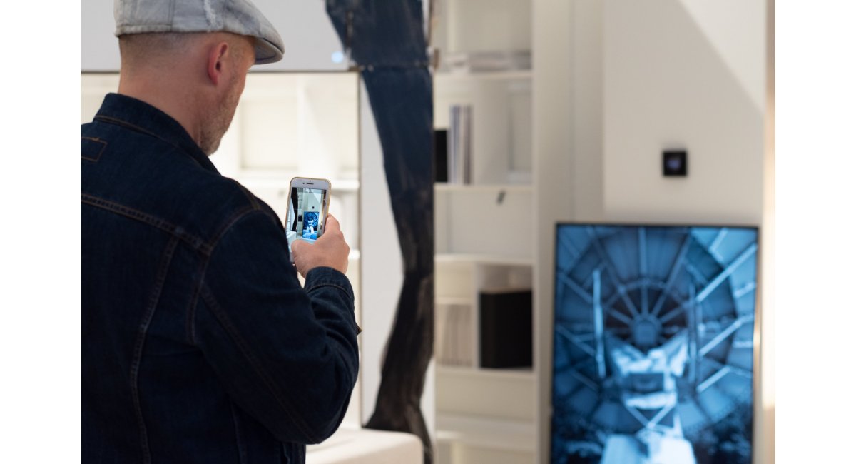 Invitado tomando foto del videoarte de Julia Oschatz