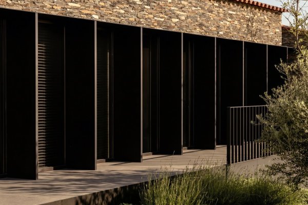 Casa Alta, Cadaqués, façana de pedra de licorella amb porticons negres — Francesc Rifé Studio per a MINIM