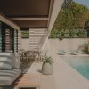 Exterior con sofás MINOTTI, sillas y mesa de B&amp;amp;B Italia y accesorios Paola Lenti en el jardín con piscina, MINIM Barcelona