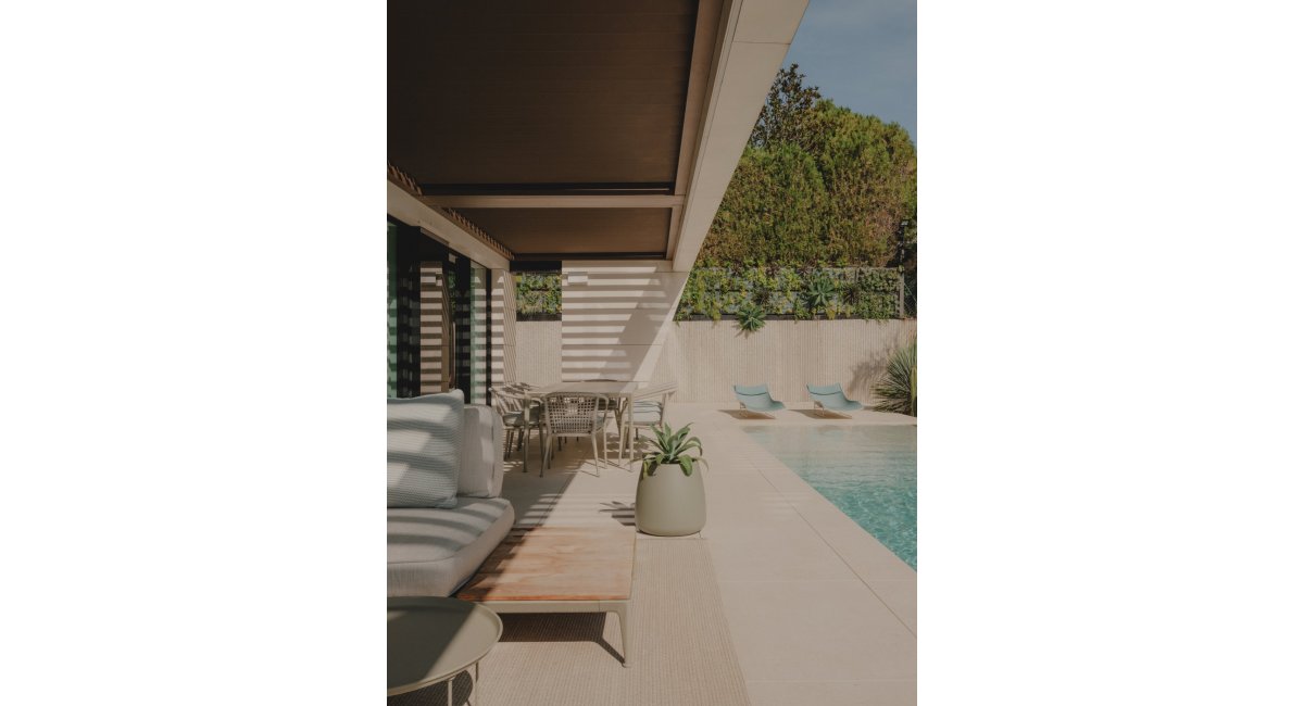 Exterior con sofás MINOTTI, sillas y mesa de B&amp;B Italia y accesorios Paola Lenti en el jardín con piscina, MINIM Barcelona