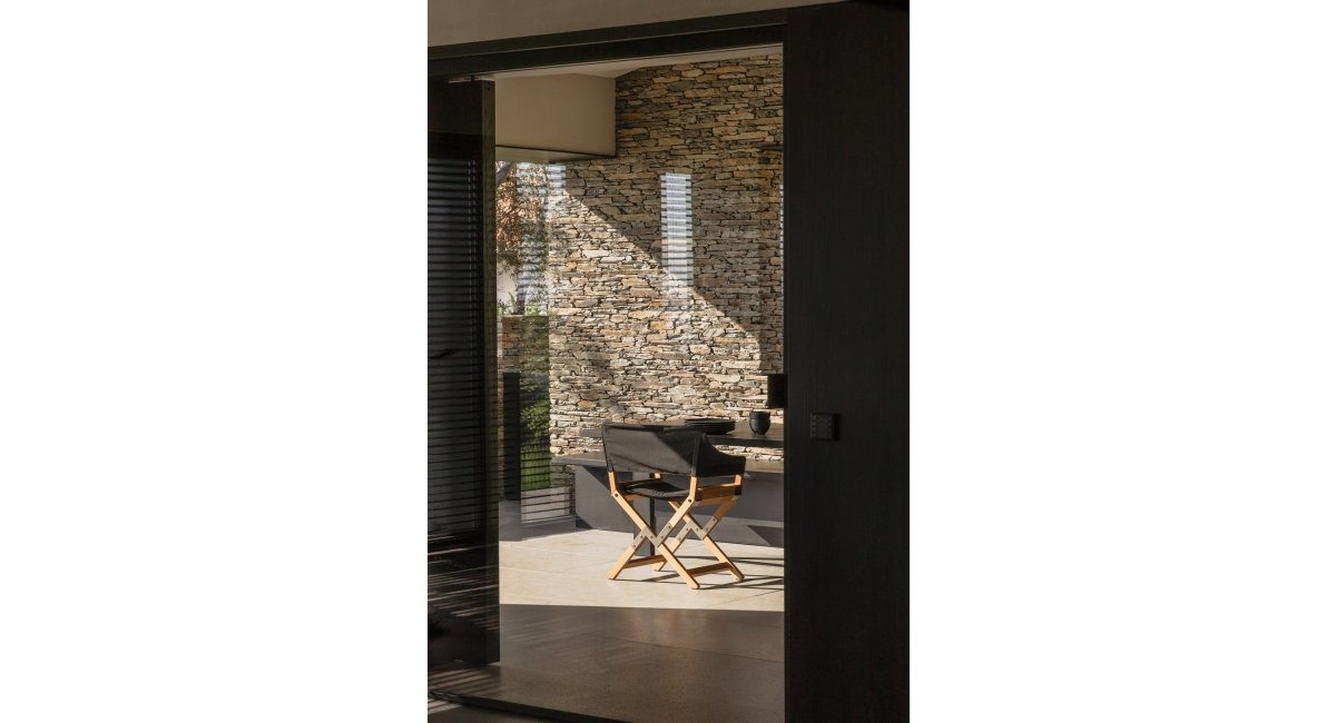 Casa Alta, Cadaqués, pati interior de pedra amb cadira plegable — Francesc Rifé Studio per a MINIM